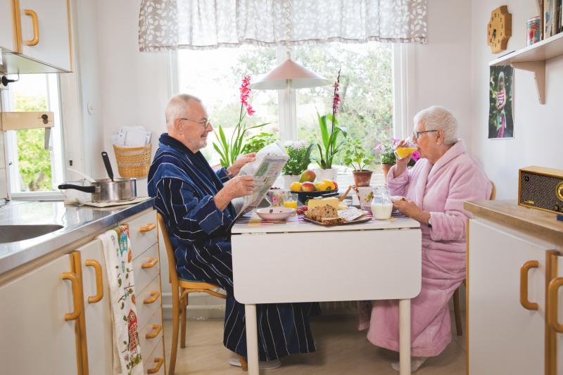 Schwedisches älteres Paar am Frühstückstisch hört Radio